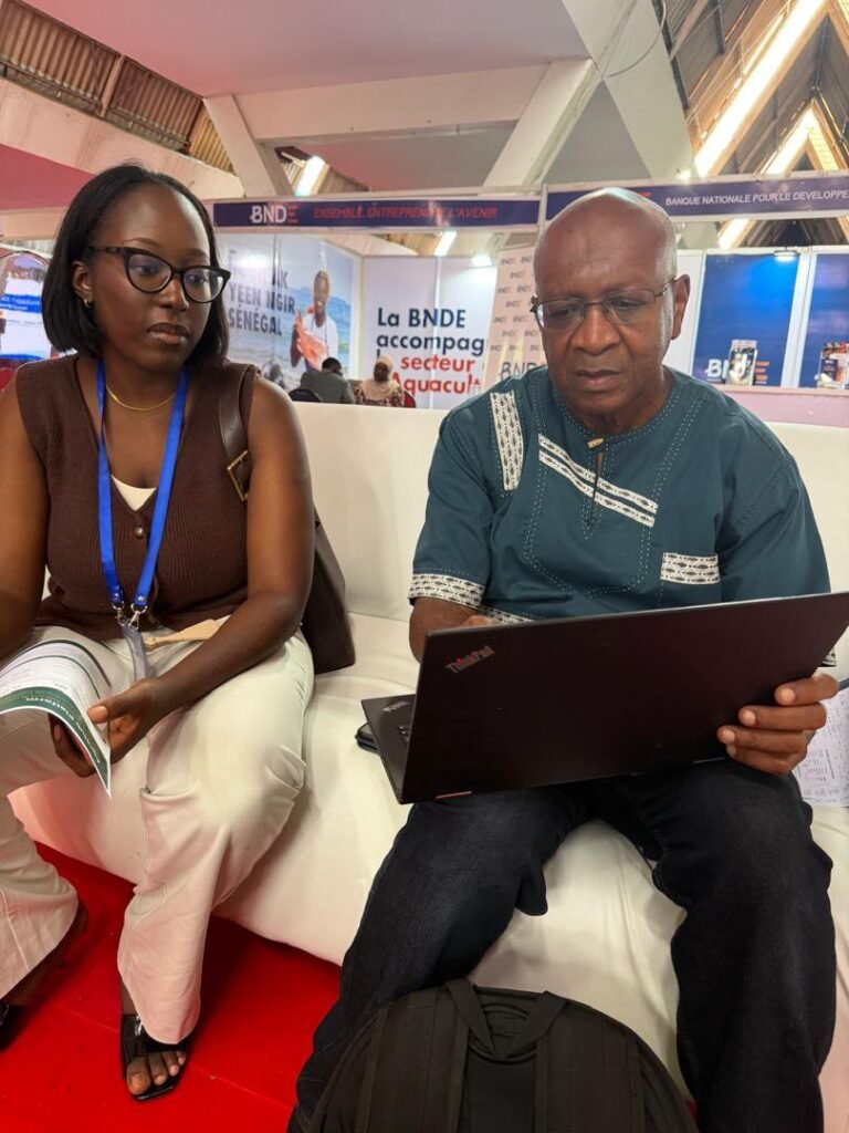 Échange pendant le Salon international de l’aquaculture de Dakar, devant le stand de la BNDE